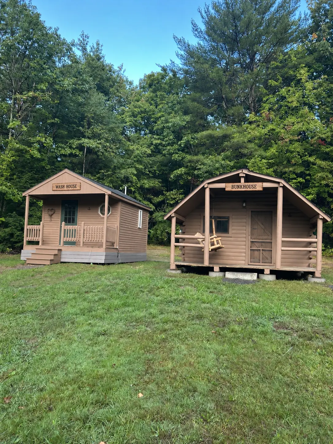 The bunkhouse and wash house in a clearing surrounded by woods