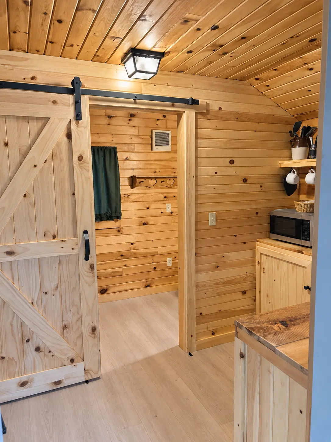 Pine-panelled interior with a sliding barn door and kitchenette