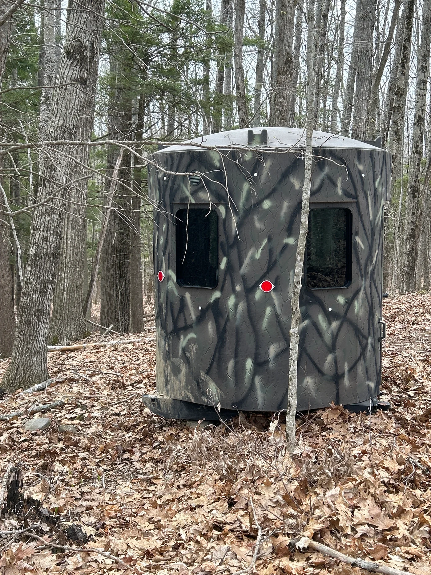 A camouflaged heated hunting blind set in the Central Maine woods